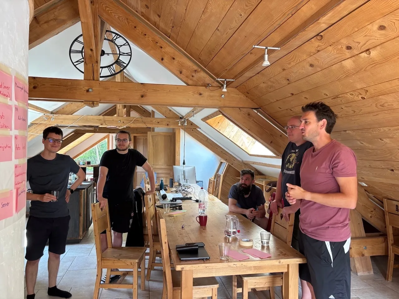 Team im Wohnzimmer vor einer Wand mit Post-Its.