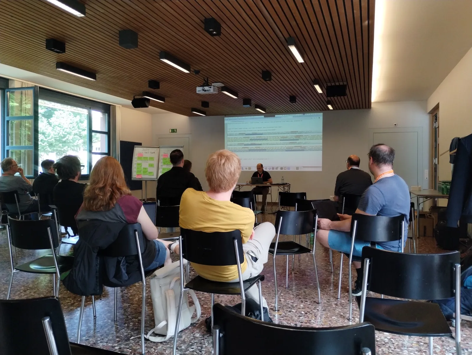 Hannes Lau bei seinem Talk zu html sitediff, hinter ihm eingeblendete Code-Snippets.