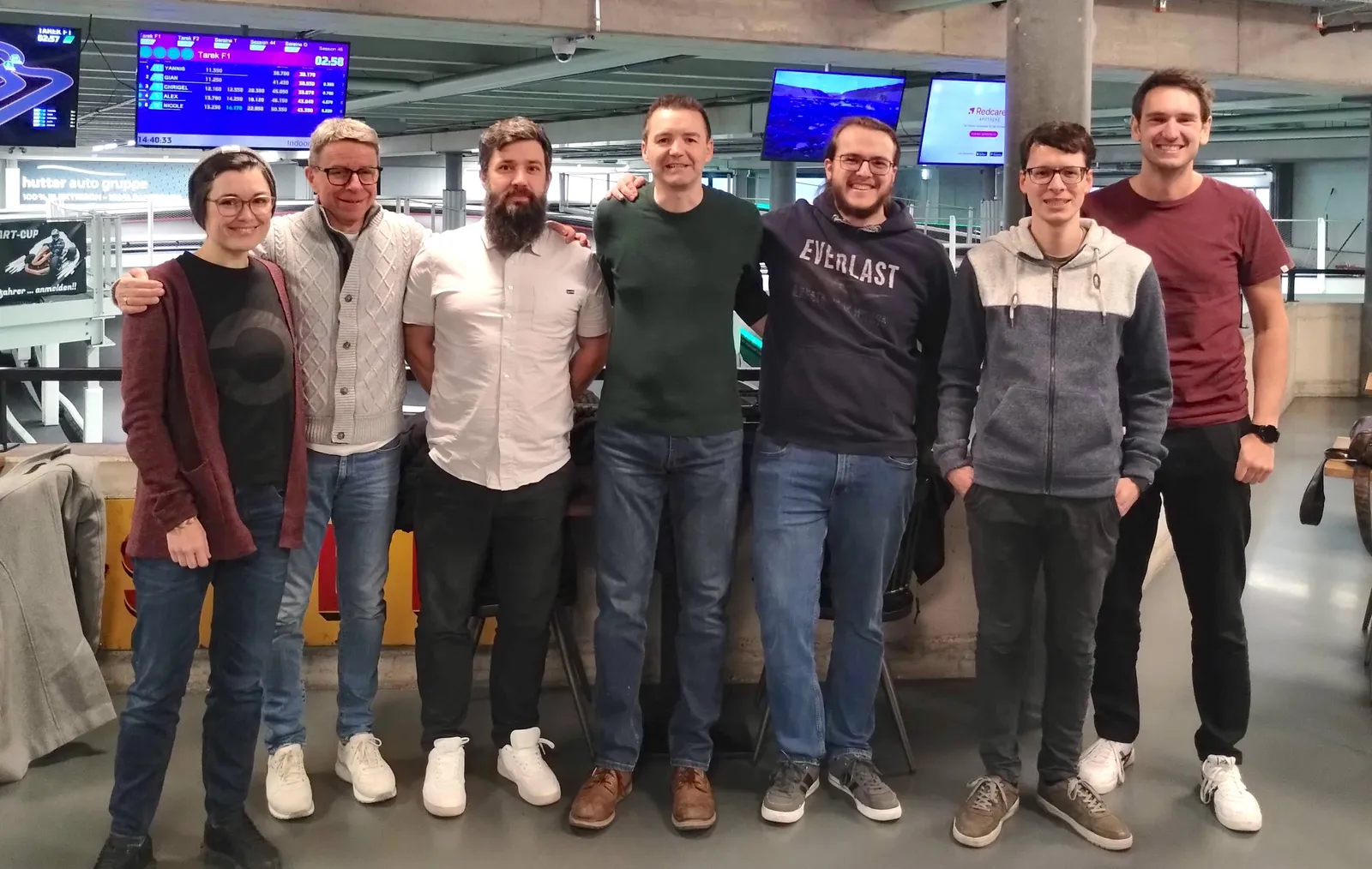 Gruppenbild des gesamten Ops One Teams inkl. VR-Präsident und Freelancer auf einer Kart-Bahn.