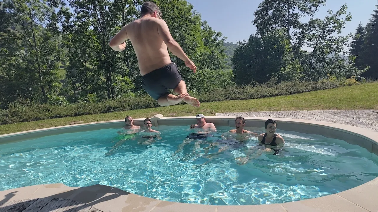 Andri in der Luft beim Sprung in den Pool, restliche Teammitglieder im Pool.
