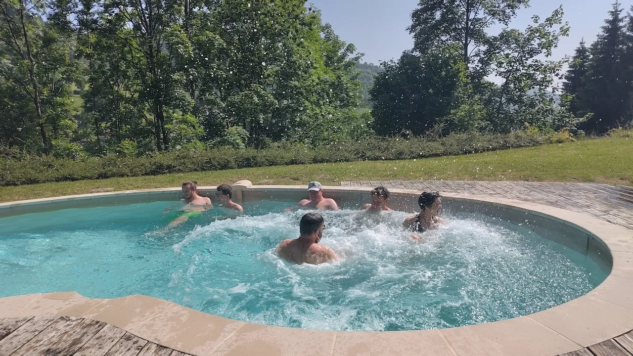 Andri nach Sprung in den Pool auftauchend in der Mitte, Rest des Teams auch im Pool drum herum.