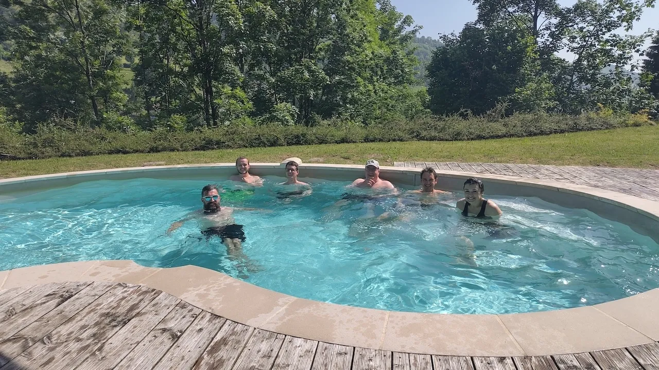 Teamfoto, alle im Pool, alle lachen in die Kamera.