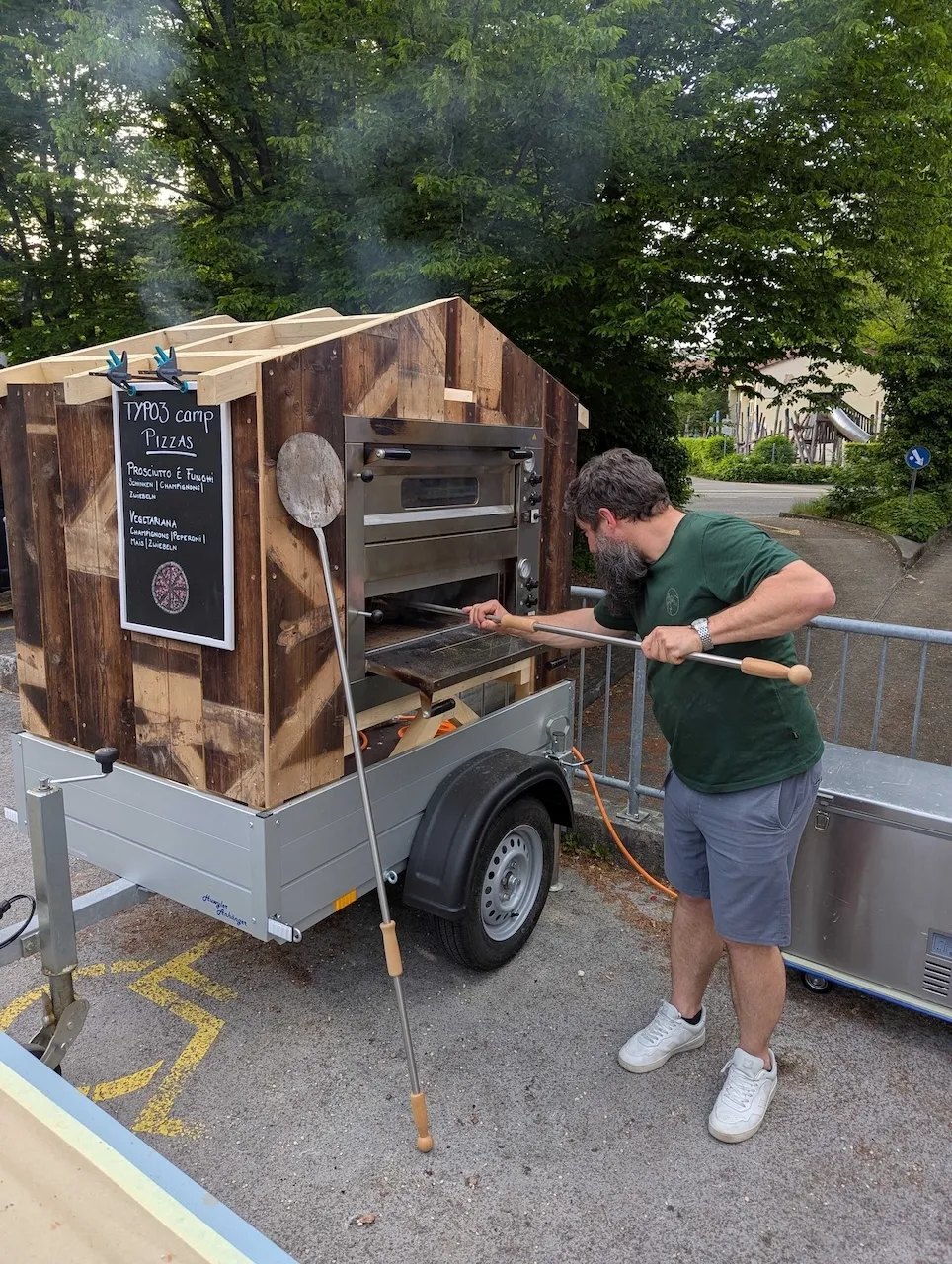Andri vor seinem selbstgebauten mobilen Pizzaofen als Pizzaiolo.