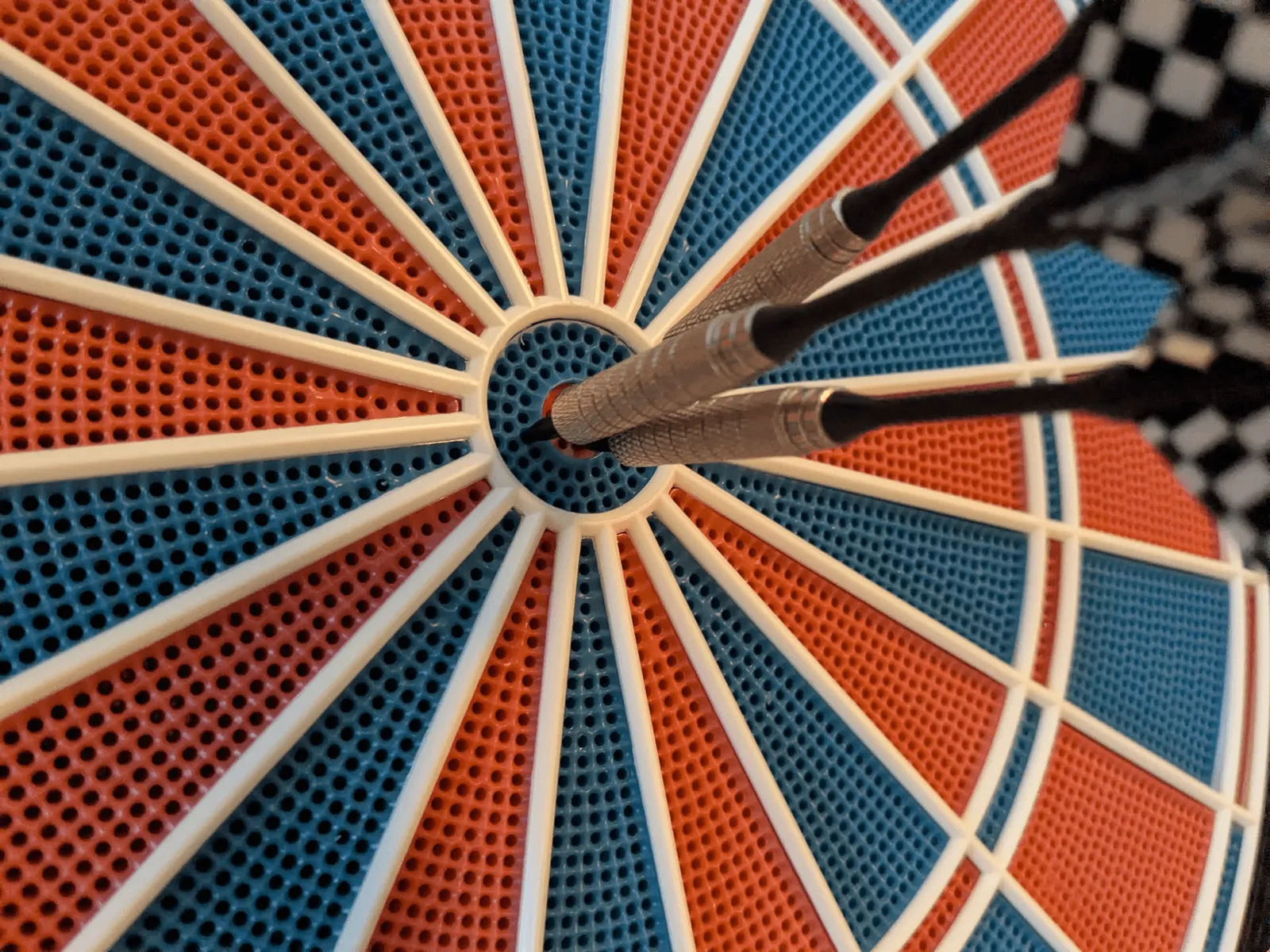 Eine Dartscheibe, bei der drei Pfeile alle im "Bullseye" (Mitte der Scheibe) stecken.
